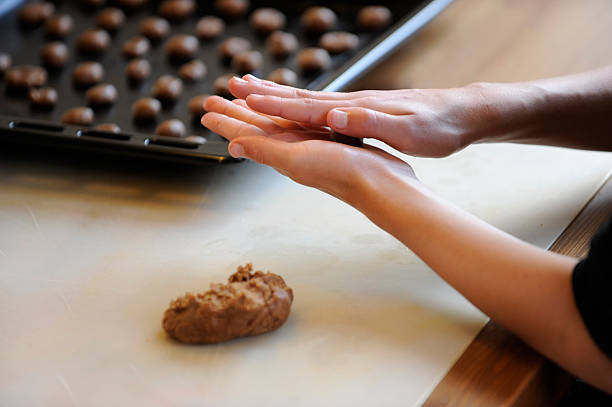 making brown spiced biscuit or pepernoten with dough - kruidnoten stockfoto's en -beelden
