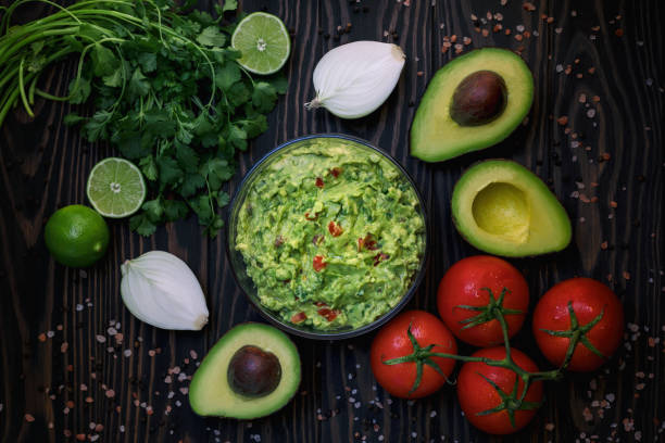 Making guacamole at home Guacamole from scratch avocado, tomato, cilantro, onion and lime guacamole stock pictures, royalty-free photos & images