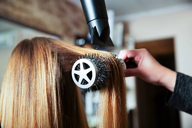 Making hairstyle using hair dryer. stock photo