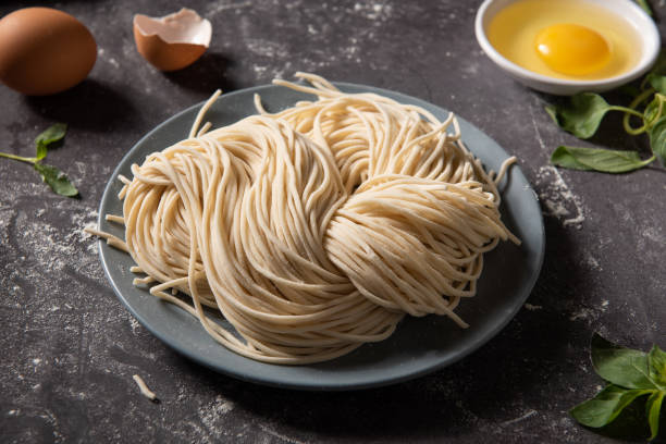 Making Handmade Noodles.raw egg noodles on board.  uncooked pasta stock pictures, royalty-free photos & images