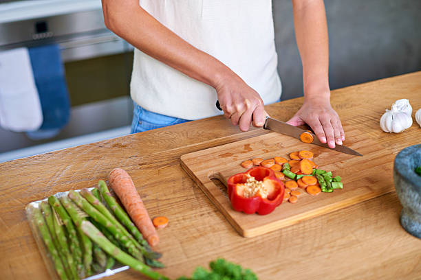Cropped shot of a woman chopping vegetables in the kitchen