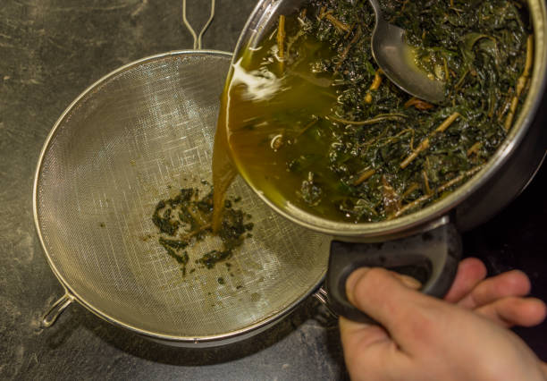 Making of marijuana butter with leafs and yellow butter which will be green stock photo