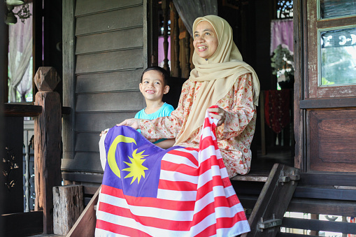 malay-muslim-mother-explaining-to-her-son-about-malaysian-flag-picture-id1161990293