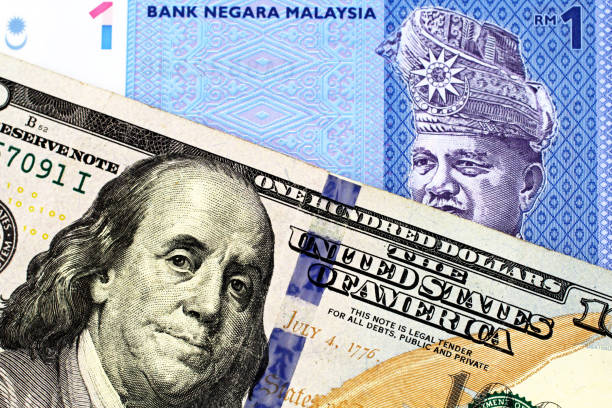 A Malaysian one ringgit bill with an American one hundred dollar bill stock photo