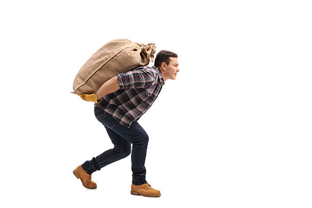 Male agricultural worker carrying burlap sack on his back Full length profile shot of a male agricultural worker carrying a burlap sack on his back isolated on white background carrying stock pictures, royalty-free photos & images