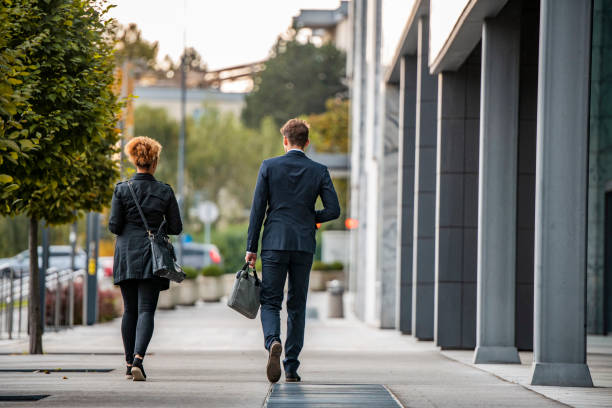 Male and Female Corporate Associates Walking Away from Camera stock photo