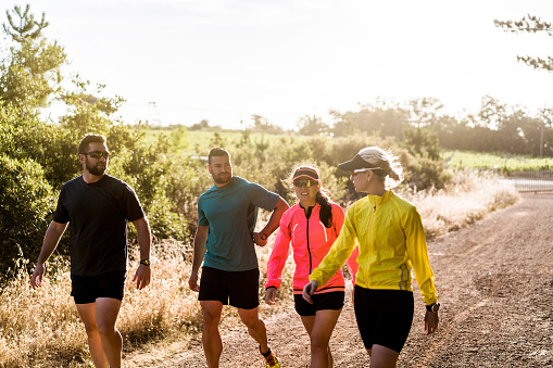 Male And Female Joggers Walking On Dirt Road Stock Photo - Download Image Now - iStock
