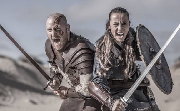 macho y hembra par guerrero de viking en campo montaña salvaje - warriors fotografías e imágenes de stock