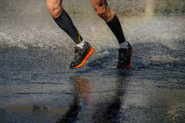male athlete in compression socks run water stock photo