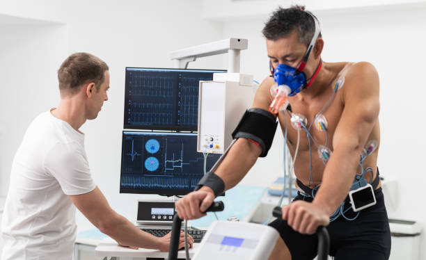 Male Athlete Performing ECG And VO2 Test On Indoor Bicycle stock photo