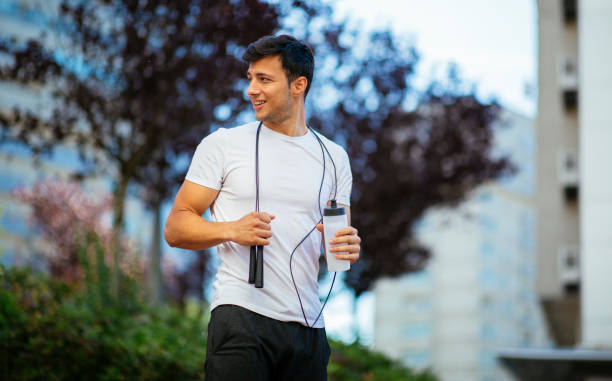 Male athlete with jumping rope looking away stock photo