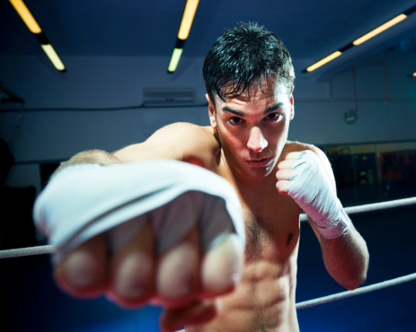 male-boxer-punching-at-camera-with-wrapped-knuckles-picture-id154277167