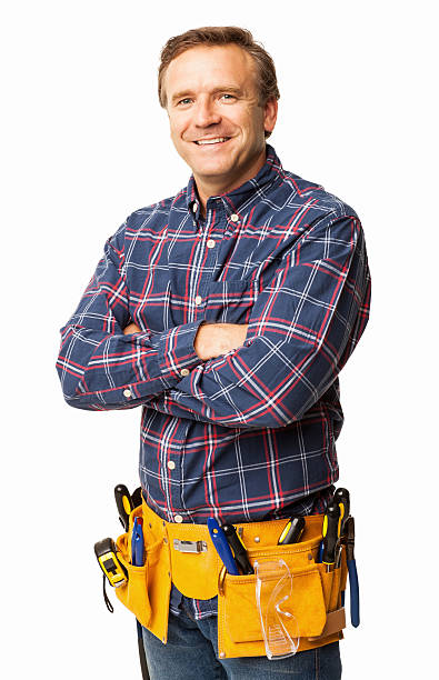 Male Carpenter Standing Confidently With a Utility Belt - Isolated Portrait of a male carpenter standing confidently with a utility belt. Vertical shot. Isolated on white. tool belt stock pictures, royalty-free photos & images
