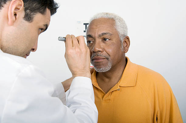 Male Doctor Testing Patient's Eye In Clinic stock photo