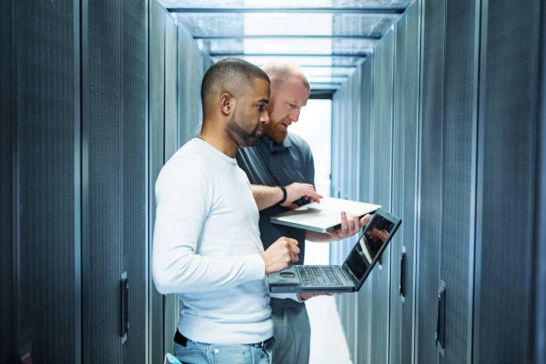 A male duo of server room technicians at business reopening stock photo