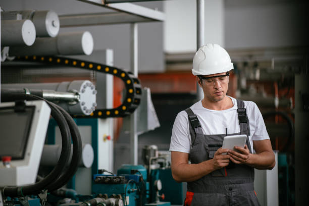 Male engineer in factory using tablet stock photo