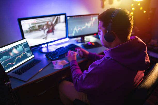Male gamer playing games online on computer for money stock photo