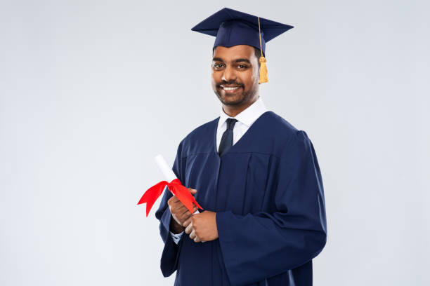 male graduate student in mortar board with diploma education, graduation and people concept - happy smiling indian male graduate student in mortar board and bachelor gown with diploma over grey background bachelor degrees stock pictures, royalty-free photos & images