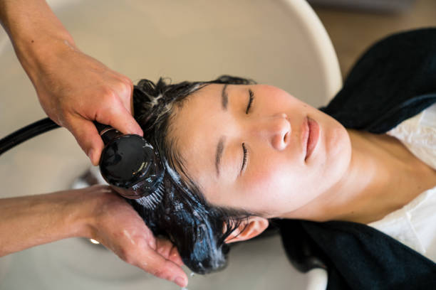 Male hairdresser washing and treating a female clients hair stock photo