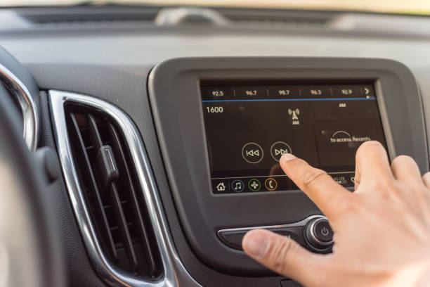 Male hand changing the radio station on car LCD infotainment screen stock photo