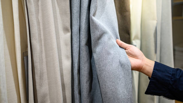 Male hand choosing curtain in furniture store stock photo