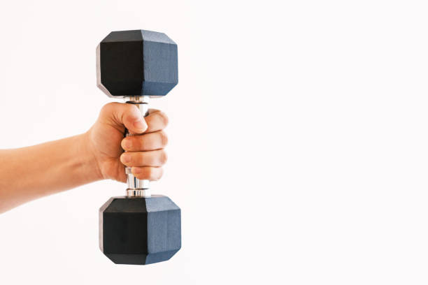 Male hand holding an iron dumbbell on white background, copy space. stock photo