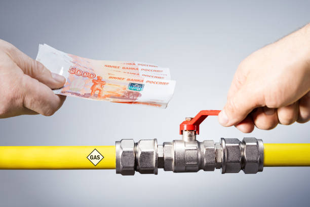 Male hand opens or closes gas valve and hand with rubles. Concept gas for rubles. stock photo