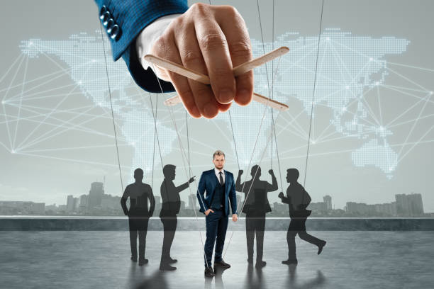 Male hand, puppeteer controls the crowd with threads, society. The concept of world conspiracy, world government, manipulation, control. stock photo