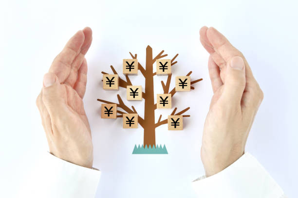 木のイラストに日本円印が付いた男性の手と木のブロック - 経済的自由 ストックフォトと画像