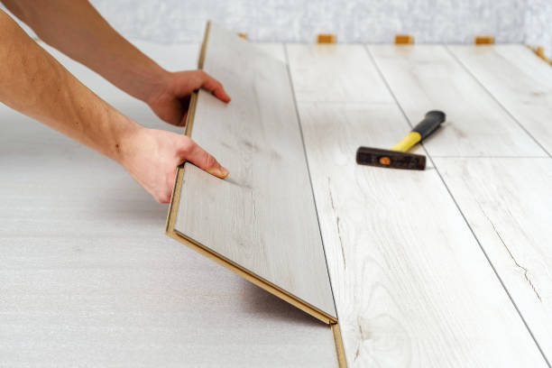 male hands is laying wooden panel of laminate floor indoors close-up. male hands is laying wooden panel of laminate floor indoors close-up. Laminate flooring, copy space wood laminate flooring stock pictures, royalty-free photos & images