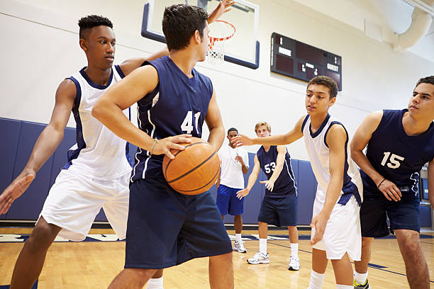 male high school basketball team playing game - basketbalspeler stockfoto's en -beelden