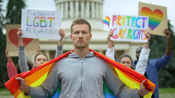 mannelijke holding rainbow vlag, vechten voor het respecteren en beschermen van lgbt rechten - gay demonstration stockfoto's en -beelden