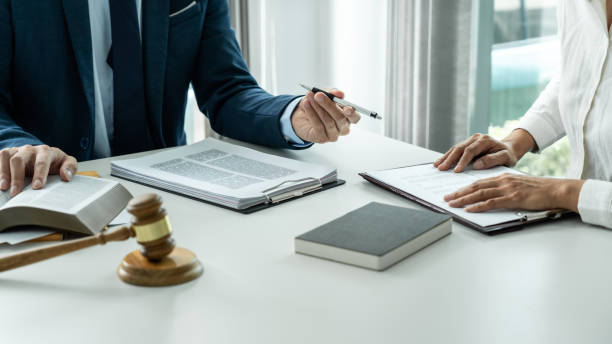 Male lawyer and professional businesswoman working and discussion having at law firm in office, Judge gavel with scales of justice stock photo