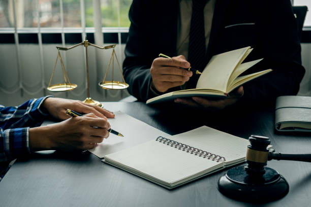 A male lawyer consults a team of legal clients and businessmen who are negotiating contracts. Human hands work with papers at the desk and sign contracts.
Keywords: on the table with hammer and scales  relationship problems stock pictures, royalty-free photos & images
