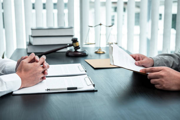 Male lawyer discussing negotiation legal case with client meeting with document contract in office, law and justice, attorney, lawsuit concept stock photo