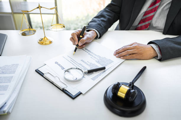 Male lawyer or judge working with contract papers, Law books and wooden gavel on table in courtroom, Justice lawyers at law firm, Law and Legal services concept stock photo