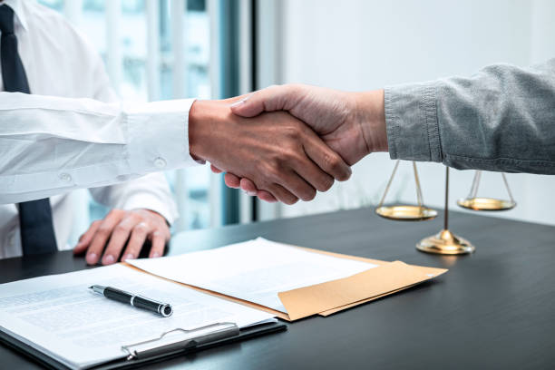 Male lawyer shaking hands with client after good deal negotiation cooperation meeting in courtroom stock photo