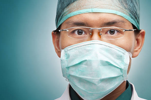 hombre trabajador de medicina mirando en serio - nurse face fotografías e imágenes de stock