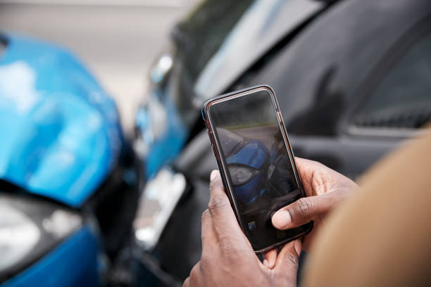 männlicher autofahrer in autounfall verwickelt und macht sich von schadenersatz für versicherungsanspruch beteiligt - handy fotos stock-fotos und bilder