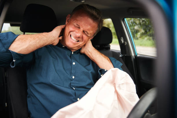mannelijke automobilist met whiplash letsel in auto-ongeluk met airbag ingezet - fixing car pain stockfoto's en -beelden