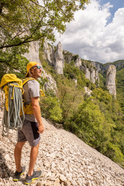 Male mountain climber looks at pinnacle rocks stock photo