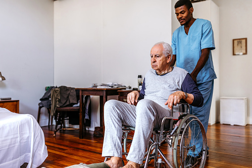 male-nurse-pushing-old-man-on-wheelchair