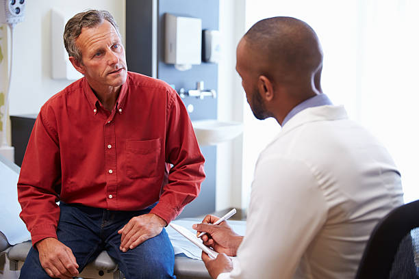 Male Patient And Doctor Have Consultation In Hospital Room Male Patient And Doctor Have Consultation In Hospital Room patience stock pictures, royalty-free photos & images