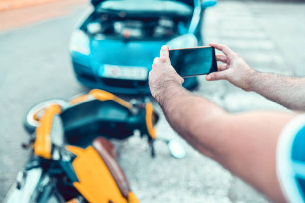 mannetje dat auto en motorfietsongeval fotografeert - fixing car pain stockfoto's en -beelden
