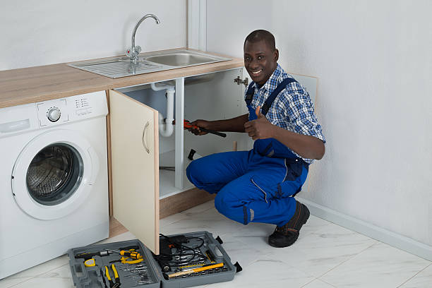 Male Plumber Fixing Sink In Kitchen Young Happy African Male Plumber Fixing Sink In Kitchen african american plumber stock pictures, royalty-free photos & images