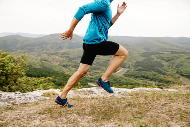 male runner run mountain trail on cliff edge stock photo