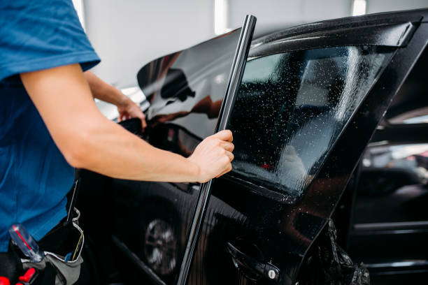 Male specialist applying car tinting film stock photo