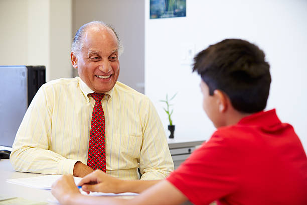 Male Student Talking To High School Counselor Male Student Talking To High School Counselor Smiling school counselor stock pictures, royalty-free photos & images