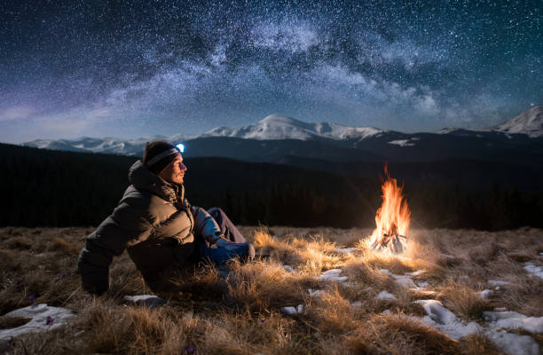 male-tourist-have-a-rest-in-the-mountains-at-night-guy-with-a-near-picture-id820843078