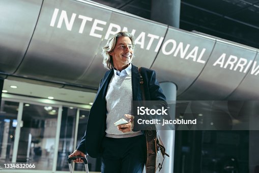 istock Male traveler with suitcase at airport 1334832066
